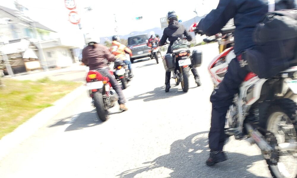 バイクで走る女性ライダー（後ろ姿）